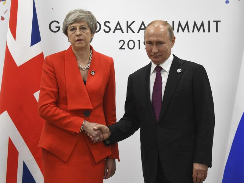 Russian President Vladimir Putin and British Prime Minister Theresa May shake hands during their meeting on the sidelines of the G20 summit in Osaka on June 28, 2019.  STR / POOL / AFP