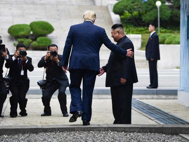 US President Donald Trump steps into the northern side of the Military Demarcation Line that divides North and South Korea, as North Korea's leader Kim Jong Un looks on, in the Joint Security Area (JSA) of Panmunjom in the Demilitarized zone (DMZ) on June 30, 2019.  Brendan Smialowski / AFP