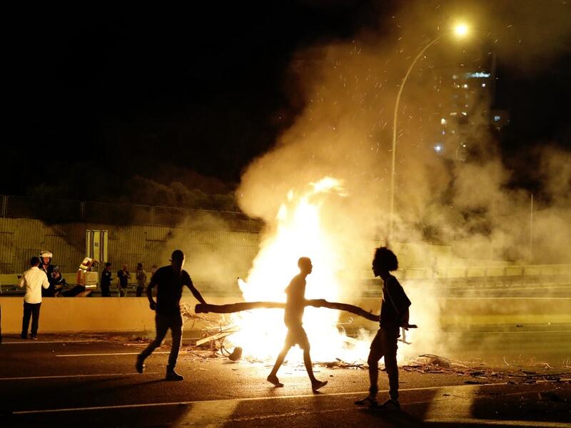 Israeli members of the Ethiopian community block a road in the coastal city of Netanya, to protest the killing of Solomon Tekah, a young man of Ethiopian origin who was killed by an off-duty police officer.  JACK GUEZ / AFP