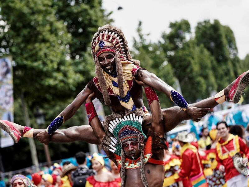 People parade during the Tropical Carnival on July, 7 2019 in Paris.  Kenzo TRIBOUILLARD / AFP
