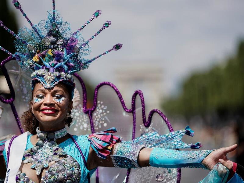 People parade during the Tropical Carnival on July, 7 2019 in Paris.  Kenzo TRIBOUILLARD / AFP