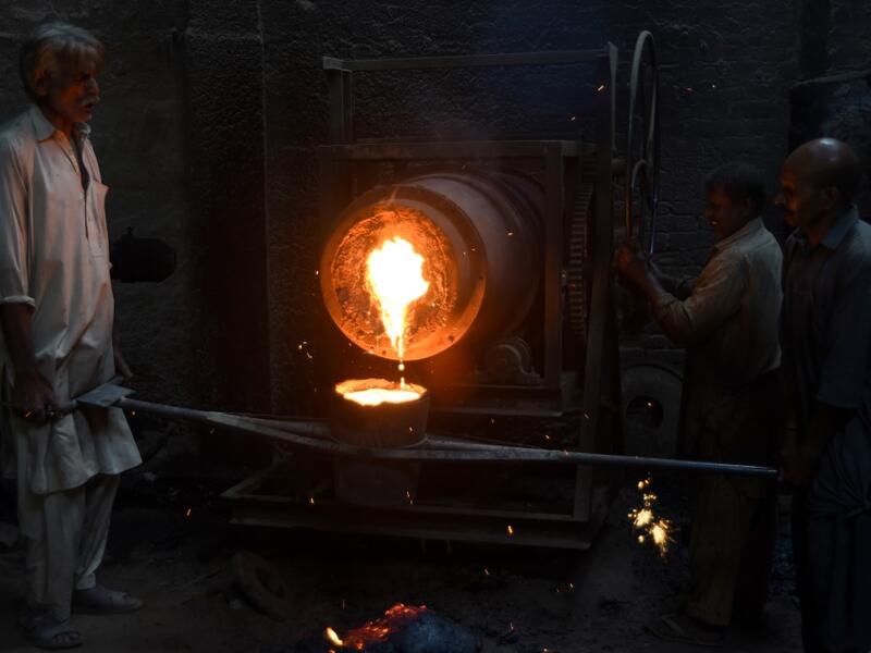 Pakistani labourers pour melted metal into a cast at an iron factory in Karachi on April 30, 2019, on the eve of the International Labour Day celebrated on May 1.  ASIF HASSAN / AFP