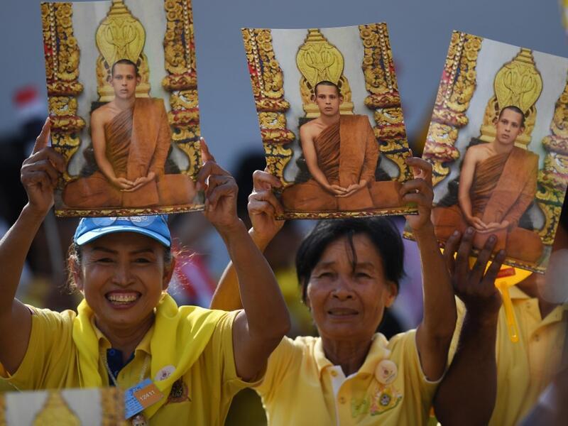 People hold portraits of Thailand's King Maha Vajiralongkorn as they wait for him and Queen Suthida to appear on the balcony of Suddhaisavarya Prasad Hall of the Grand Palace to grant a public audience on the final day of his royal coronation in Bangkok on May 6, 2019.  Lillian SUWANRUMPHA / AFP
