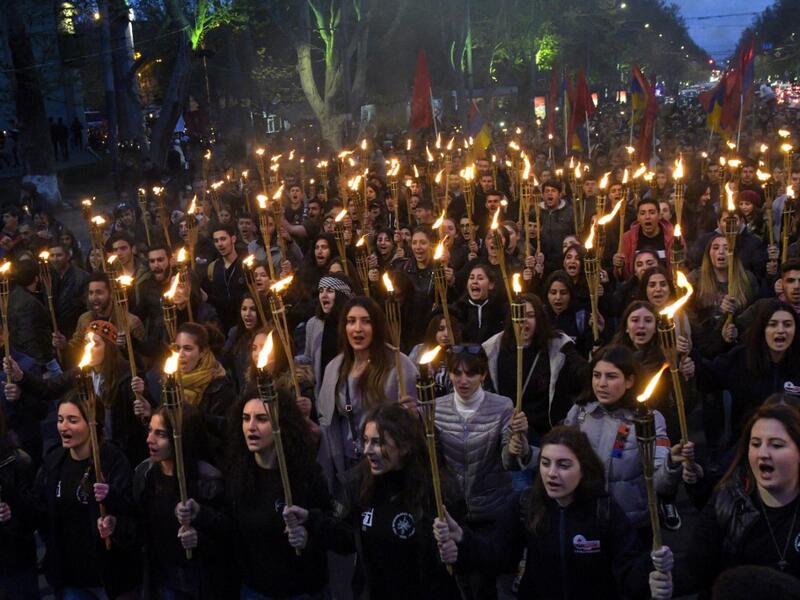 People take part in a torchlight procession as they mark the anniversary of the killing of 1.5 million Armenians by Ottoman forces, Yerevan, April 23, 2019. KAREN MINASYAN / AFP