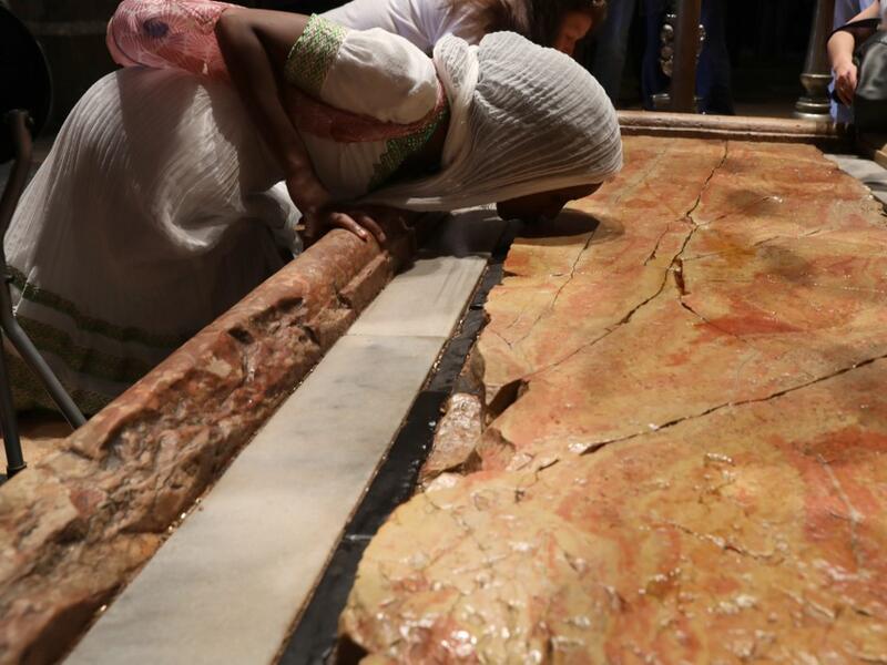 An Orthodox pilgrim kisses the anointment stone at the church of the Holy Sepulchre in Jerusalem's Old City, on April 25, 2019, during the Orthodox Holy Week.  GALI TIBBON / AFP