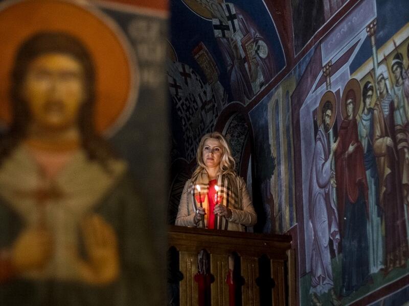 A North Macedonian Orthodox Christian woman holds candles as she takes part in midnight Easter services at the Kalishta Monastery, in the village of Kalishta near Struga, on April 27, 2019.  Robert ATANASOVSKI / AFP