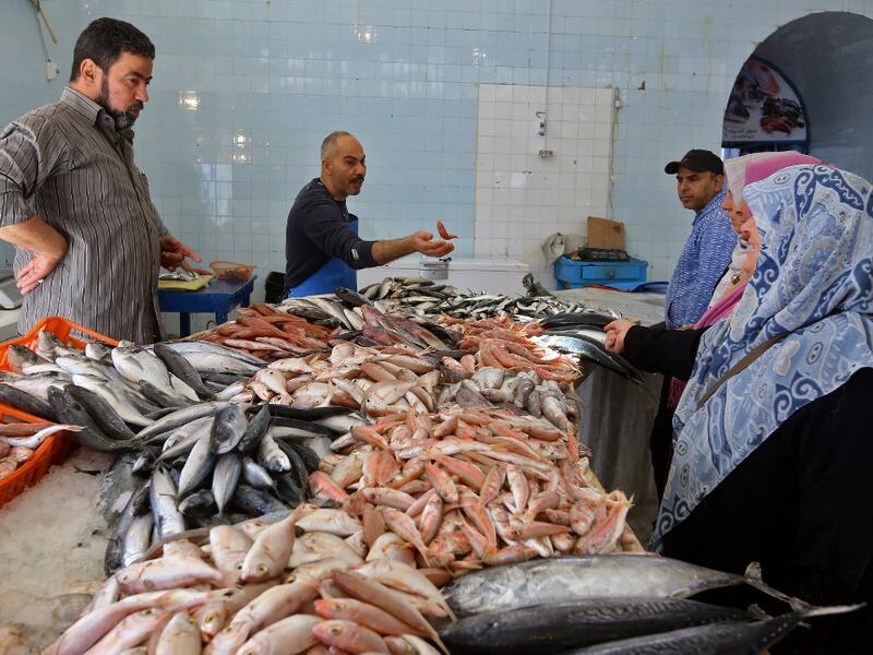 Libyans buy fresh fish at a market as residents of the capital Tripoli get ready for the beginning of the fasting month of Ramadan on May 1, 2019. Mahmud TURKIA / AFP