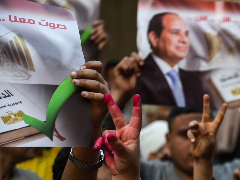 Egyptian people show their inked hands after voting at a polling station during the third day of a referendum on constitutional amendments, at a school in shamma village in the northern Nile delta province of Menoufia, on April 22, 2019.  Mohamed el-Shahed / AFP