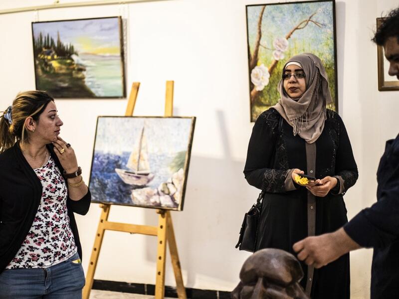 Residents of the eastern Syrian city of Raqa view artworks during an exhibition at the first cultural centre to open since ISIS rule ended there, on May 1, 2019. DELIL SOULEIMAN / AFP