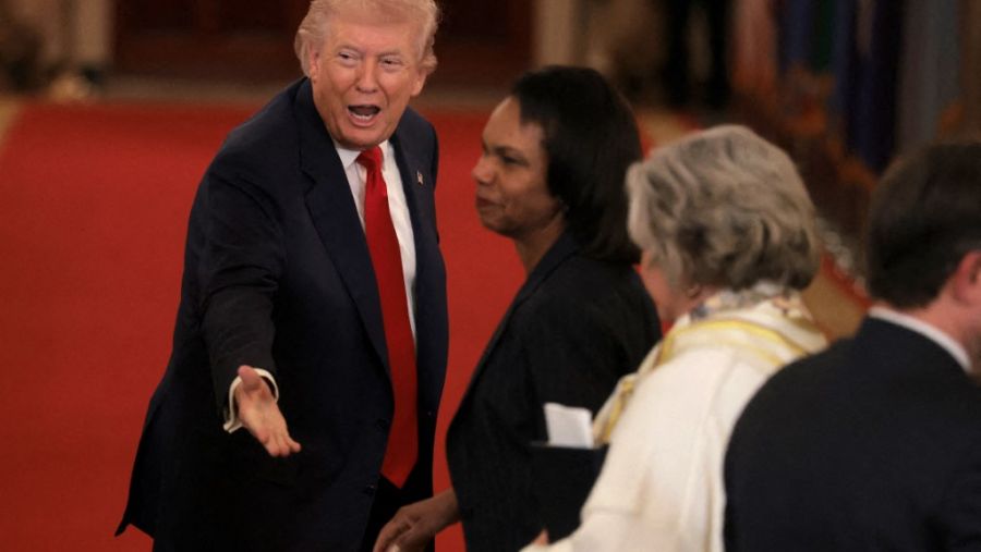  U.S. President Donald Trump speaks to former U.S. Secretary of State Condoleezza Rice