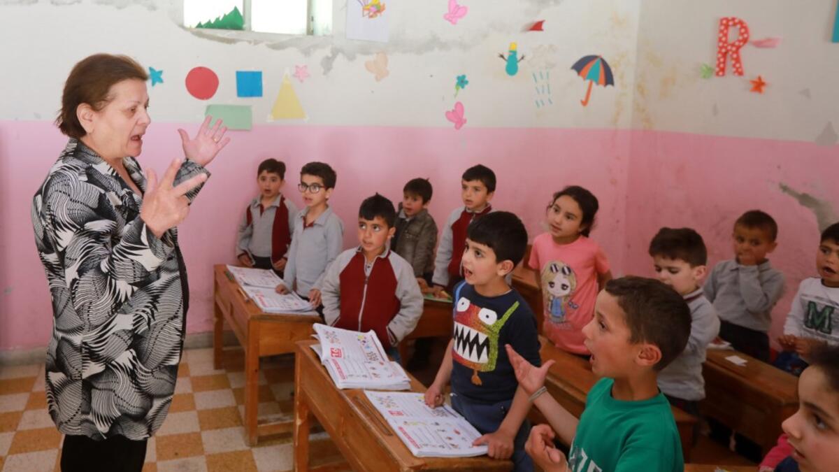 Antoinette Makh, instructs her pupils in the Aramaic language at a school in the Syrian mountain village of Maalula, in the Damascus region on May 13, 2019. LOUAI BESHARA / AFP
