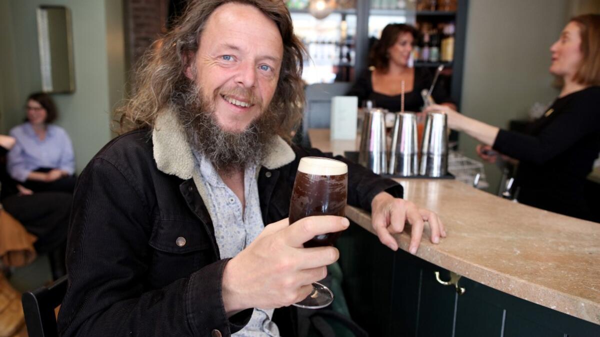 A patron poses with a non-alcoholic beer at the Virgin Mary pub, which opened recently selling non-alcoholic drinks and is known as the 'pub with no beer', in the city centre of Dublin on May 16, 2019. PAUL FAITH / AFP