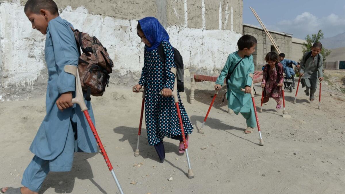 In this photograph taken on September 8, 2018, Afghan disabled children belonging to Hamisha Gul family who lost their legs following unexploded rocket explosion, walk outside their house after a class in Khogyani the district of Nangarhar province. NOORULLAH SHIRZADA / AFP