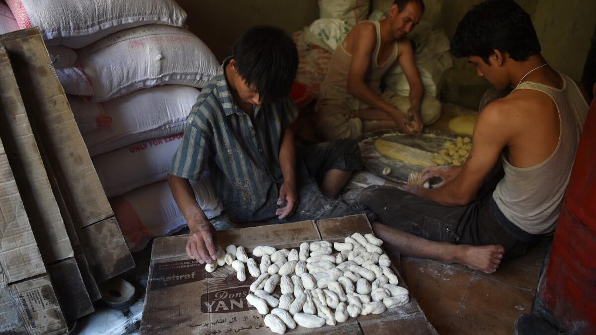 An Afghan worker prepares khajor, a local cooky made from flour and sugar, ahead of the Eid al-Fitr festival, which marks the end of Islamic holy month of Ramadan at a traditional sweets factory in Kabul on June 2, 2019. WAKIL KOHSAR / AFP