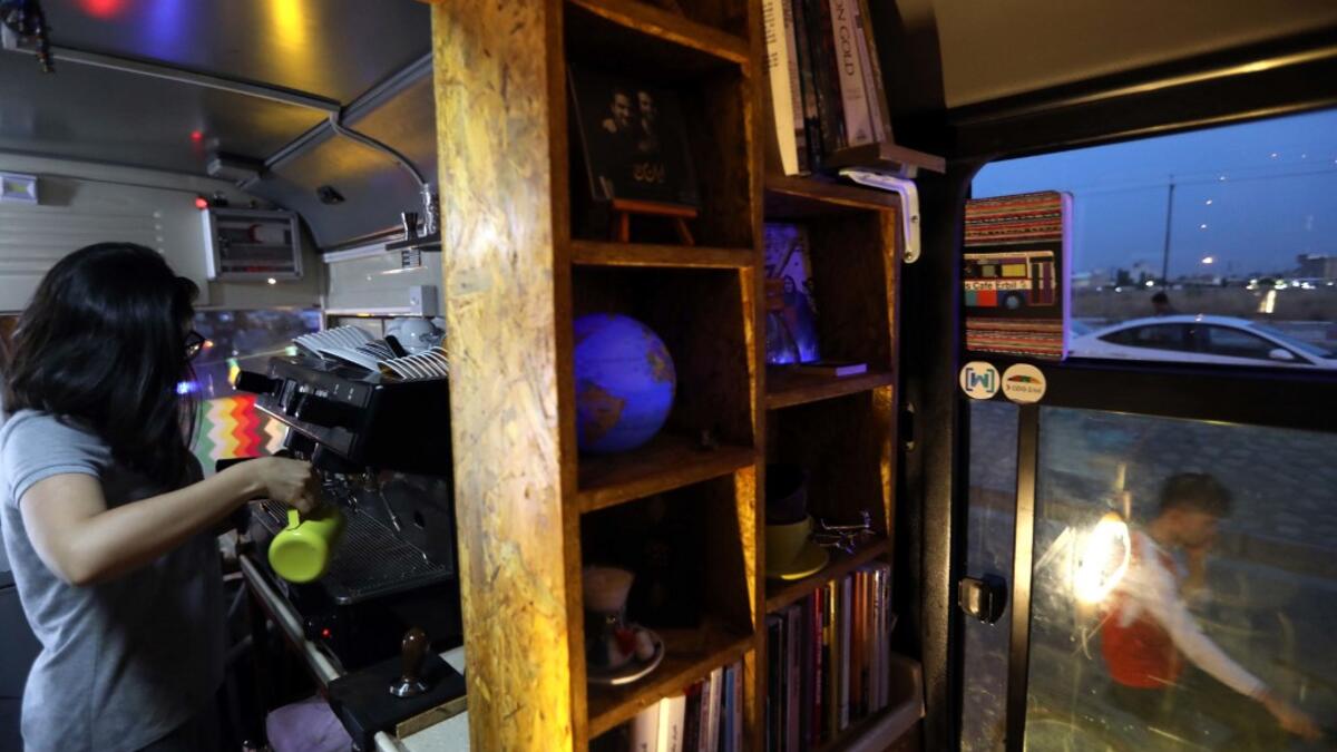 Kani Jalil, a 22-year-old Iraqi Kurdish woman who runs with her husband "The Bus Cafe Erbil" in Arbil, prepares a coffee for clients inside her cafe in Arbil, the capital of Iraq's Kurdish autonomous region, late on June 7, 2019, on the long weekend of the Eid al-Fitr holiday which marks the end of the Muslim holy month of Ramadan.  SAFIN HAMED / AFP