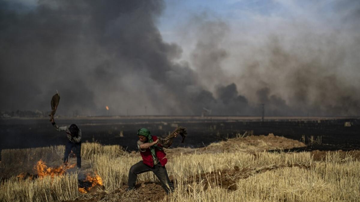 People battle a blaze in an agricultural field in the town of al-Qahtaniyah, in the Hasakeh province near the Syrian-Turkish border on June 10, 2019. Fires have erupted in various parts of Syria in recent weeks, with all sides blaming each other for starting them. Delil souleiman / AFP