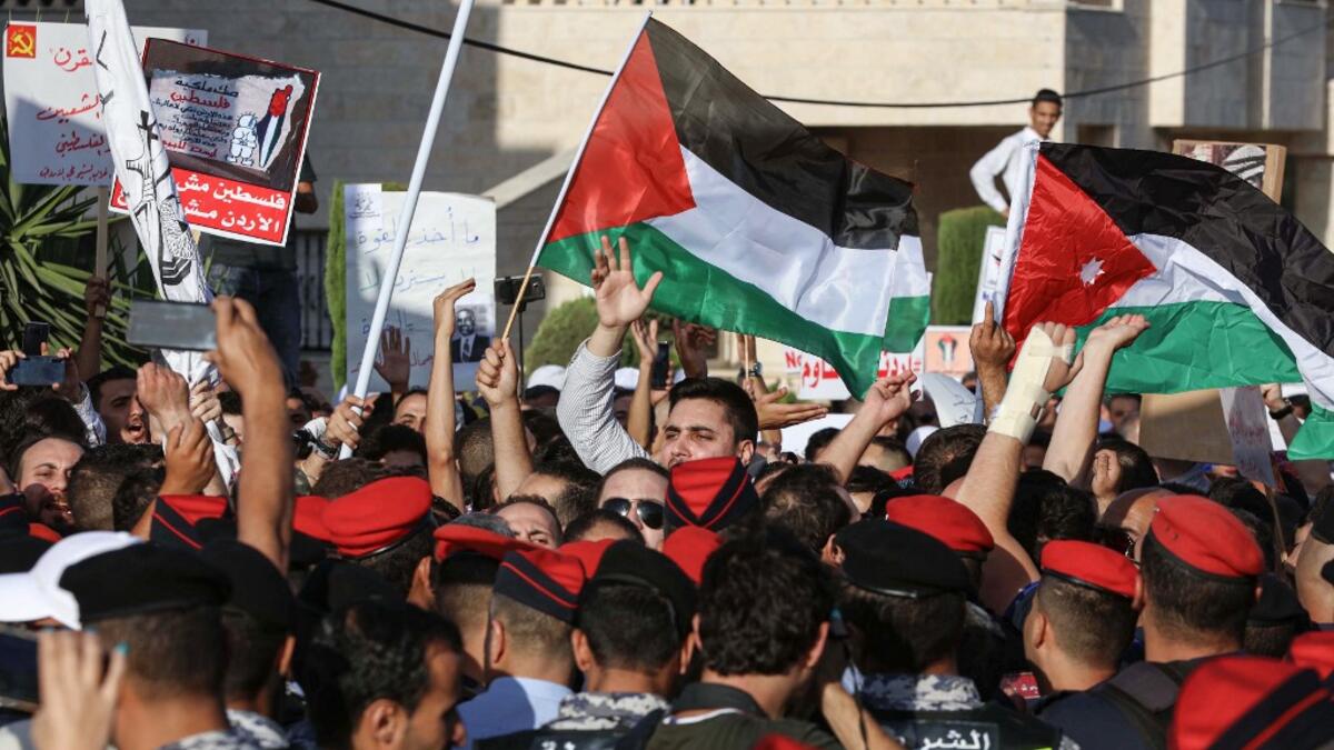 Protesters wave Palestinian (C) and Jordanian (R) flags as they chant slogans during the "March of Anger" demonstration leading to the US Embassy in the Jordanian capital Amman on June 21, 2019, against the US President's "Deal of the Century" and the US-led Middle East economic conference in Bahrain.  Khalil MAZRAAWI / AFP