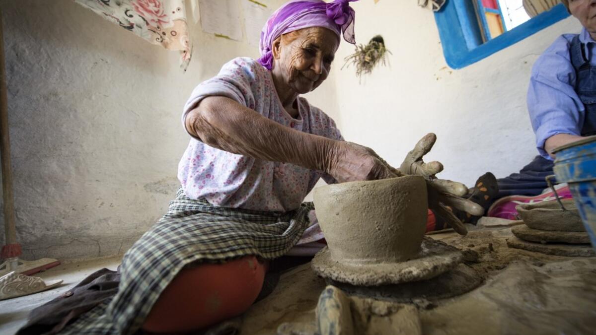 Moroccan potter Aicha Tabiz (L), also known as Mama Aicha, sits next to British apprentice Kim West (R), 33, during a pottery workshop near the village of Ourtzagh in the foothills of the Rif mountains on June 12, 2019. FADEL SENNA / AFP