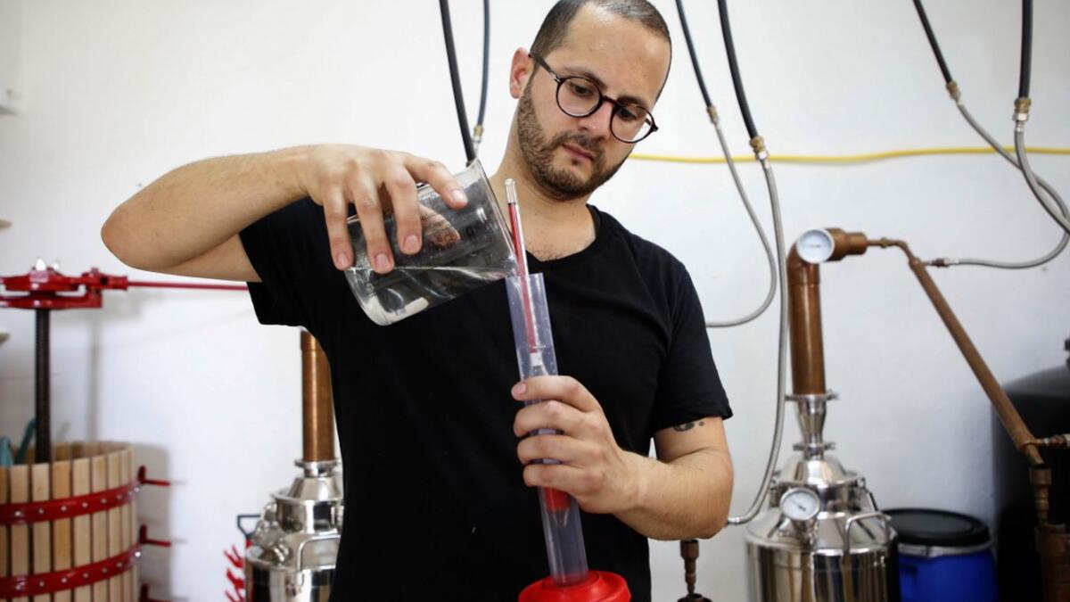 Palestinian distiller Nader Muaddi uses an alcoholometer to measure the amount of alcohol in his Arak in the West Bank village of Beit Jala, near Bethlehem, on June 16, 2019. In his basement, distiller Muaddi made fewer than 500 bottles of liquor last year, but it is earning global acclaim and reviving interest in the Palestinian alcohol sector. On the outskirts of the city famed for Jesus's birth, the 35-year-old illustrates the handcrafted way he makes Arak, an anise-flavoured drink popular in the Middle