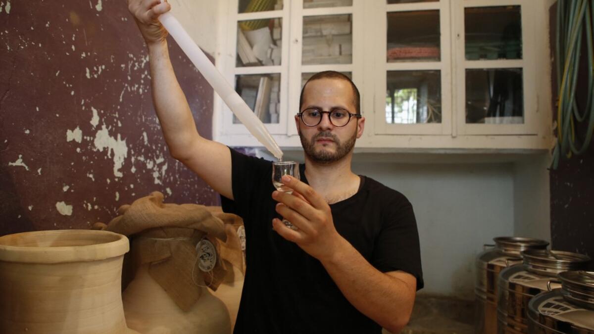 Palestinian distiller Nader Muaddi uses an alcoholometer to measure the amount of alcohol in his Arak in the West Bank village of Beit Jala, near Bethlehem, on June 16, 2019. In his basement, distiller Muaddi made fewer than 500 bottles of liquor last year, but it is earning global acclaim and reviving interest in the Palestinian alcohol sector. On the outskirts of the city famed for Jesus's birth, the 35-year-old illustrates the handcrafted way he makes Arak, an anise-flavoured drink popular in the Middle
