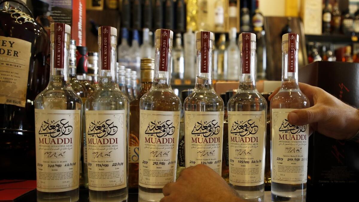 Palestinian Muaddi Arak bottles are displayed at a shop in the West Bank village of Beit Jala, near Bethlehem, on June 16, 2019. In his basement, distiller Muaddi made fewer than 500 bottles of liquor last year, but it is earning global acclaim and reviving interest in the Palestinian alcohol sector. On the outskirts of the city famed for Jesus's birth, the 35-year-old illustrates the handcrafted way he makes Arak, an anise-flavoured drink popular in the Middle East and similar to Greek Ouzo, French Pastis