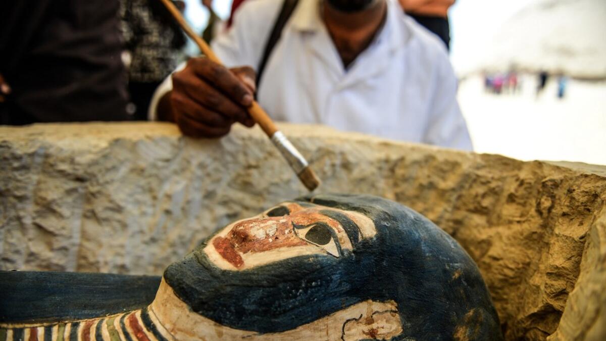 A man brushes off dust from a sarcophagus, part of a new discovery carried out almost 300 meters south of King Amenemhat II’s pyramid at Dahshur necropolis, exposed near the Bent Pyramid. Mohamed el-Shahed / AFP