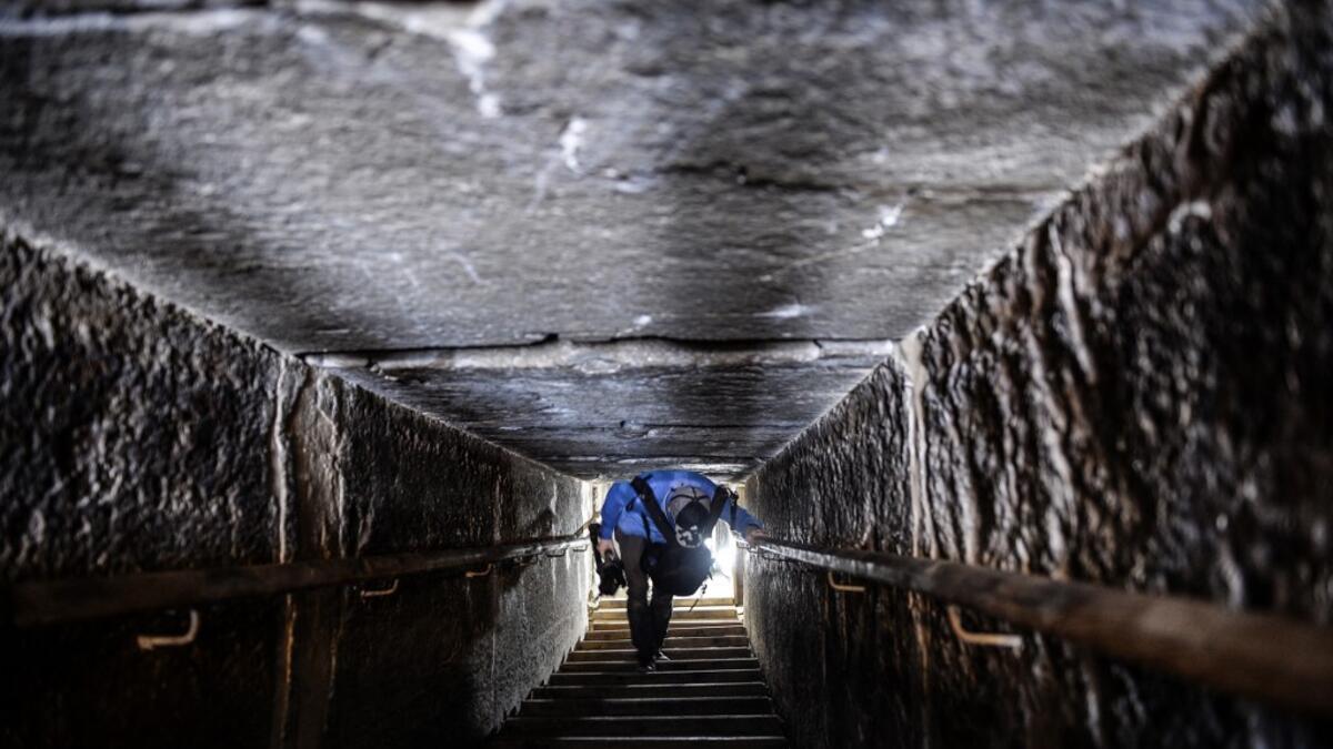 A man walks through a passage in the well-known bent pyramid of King Snefru, which had been closed to visitors since 1965, in Dahshur, some 30 kilometres (20 miles) south of Cairo, on July 13, 2019, after it was reopened by the Egyptian Antiquities Minister. Mohamed el-Shahed / AFP