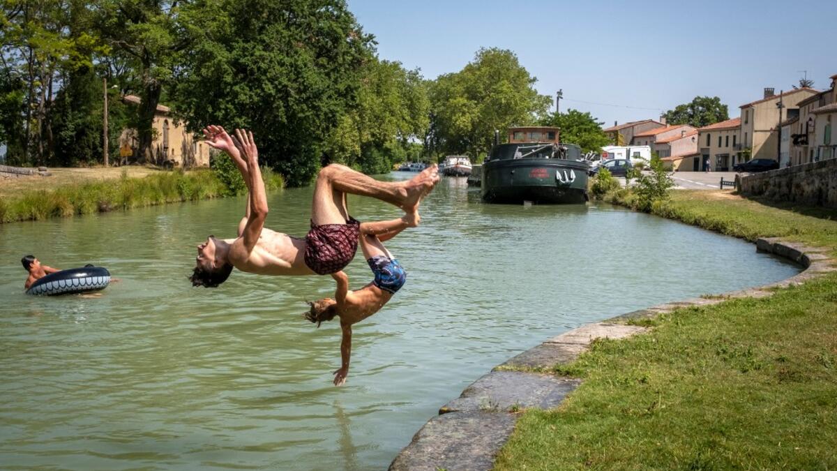 Young men dive into the Canal du Midi at the Port du Segala in Labastide d'Anjou on July 23, 2019 as a new heatwave blasted into northern Europe that could set records in several countries. ERIC CABANIS / AFP
