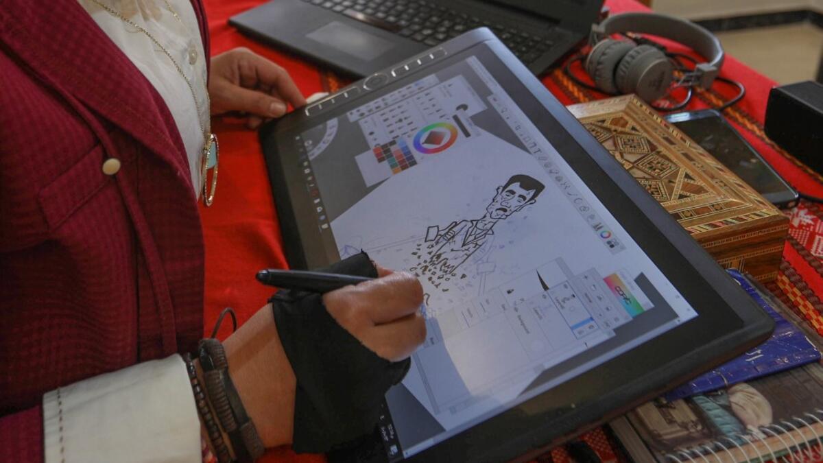 Syrian cartoonist Amani al-Ali sketches a portrait of President Bashar al-Assad in her home studio in the city of Idlib in the eponymous northwestern province.  Omar HAJ KADOUR / AFP