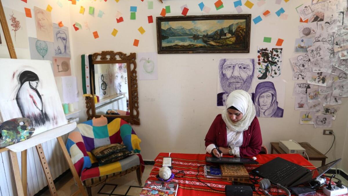 Syrian Cartoonist Amani al-Ali draws an illustration on a digital tablet device in her home studio in the city of Idlib in the eponymous northwestern province Omar HAJ KADOUR / AFP