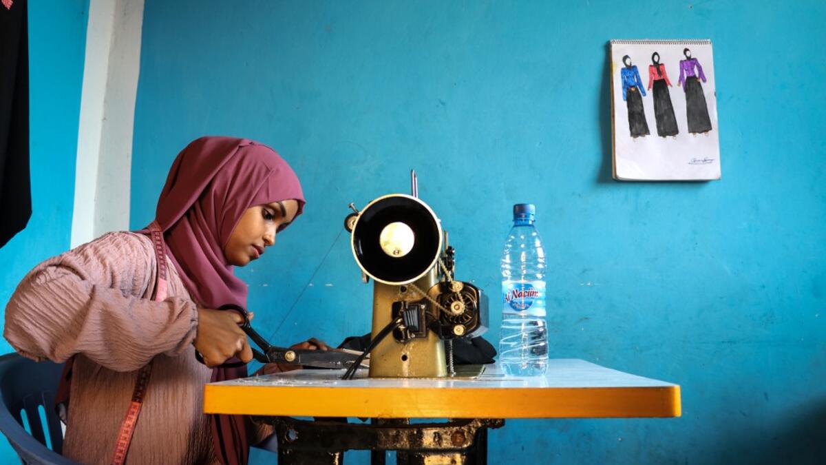 Hawa Adan Hassan, 23 year-old, university student, uses a sewing machine at her home in Mogadishu, Somalia. Abdi HAJJI HUSSEIN / AFP