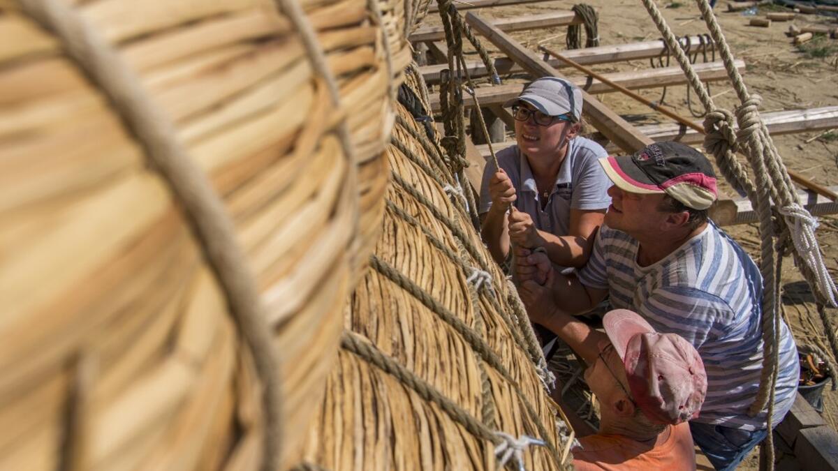 Members of the crew assemble the 14-meter long sailing reed boat Abora IV in the town of Beloslav, Bulgaria, on July 25, 2019. NIKOLAY DOYCHINOV / AFP