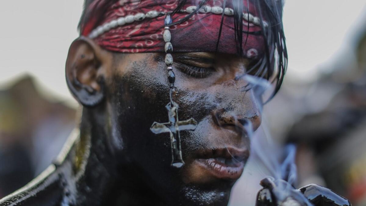 A catholic faithful smeared in burnt oil, takes part in the opening of the ten-day celebration of the Santo Domingo de Guzman festival in Managua, on August 1, 2019.  INTI OCON / AFP