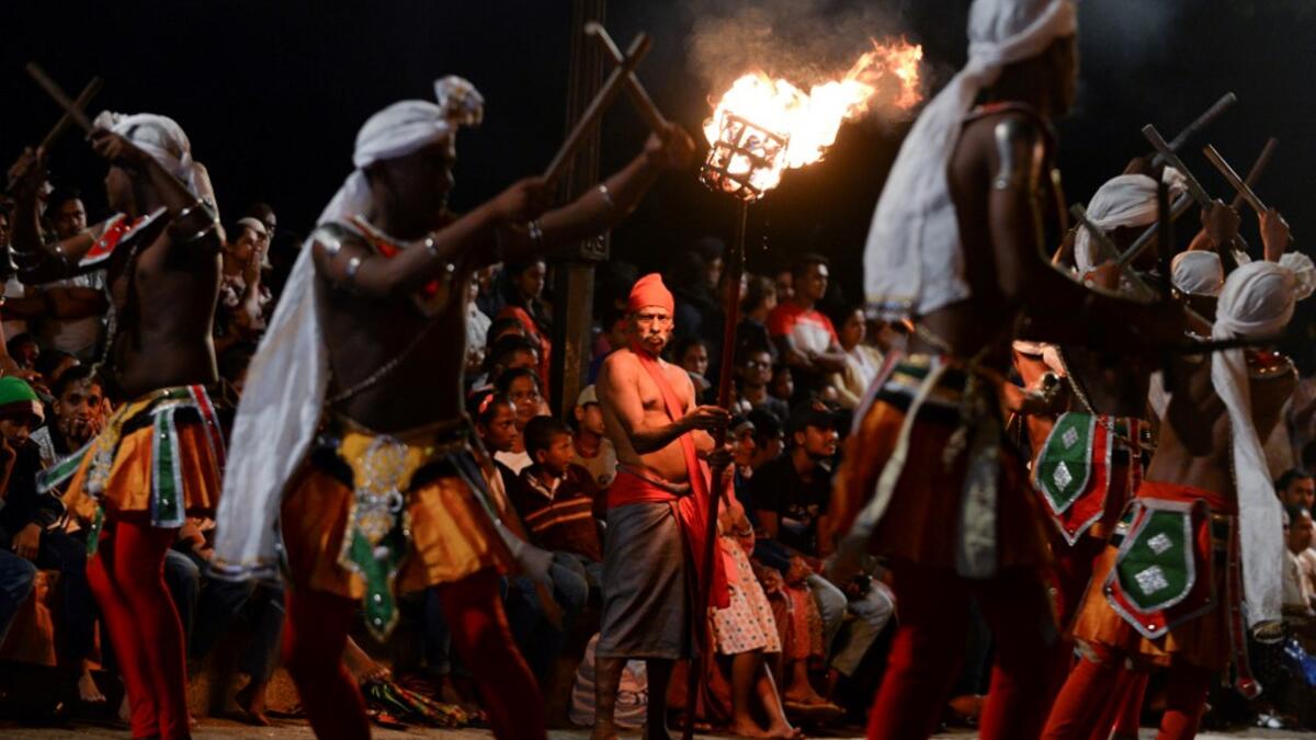 In this photograph taken on August 14, 2019 dancers perform during the "Esala Perahera" festival near the Buddhist temple of the Tooth in the ancient hill capital of Kandy, some 116 kilometres from Colombo. Lakruwan WANNIARACHCHI / AFP