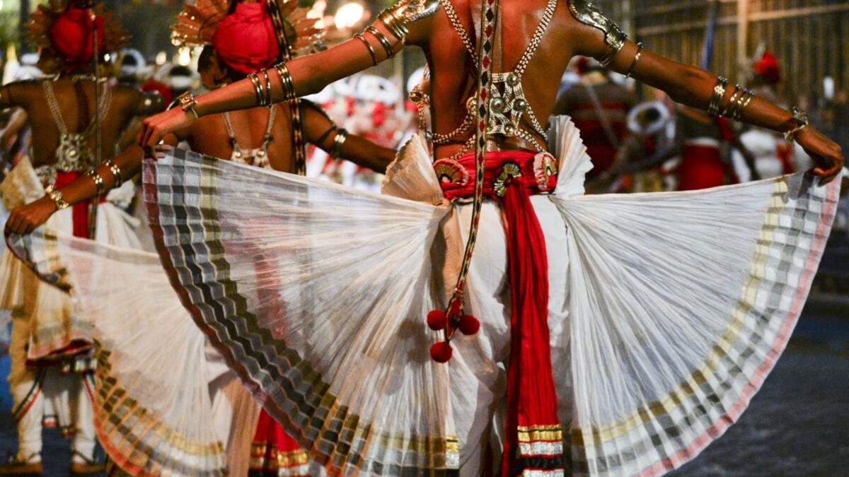 In this photograph taken on August 14, 2019 dancers perform during the "Esala Perahera" festival near the Buddhist temple of the Tooth in the ancient hill capital of Kandy, some 116 kilometres from Colombo. Lakruwan WANNIARACHCHI / AFP