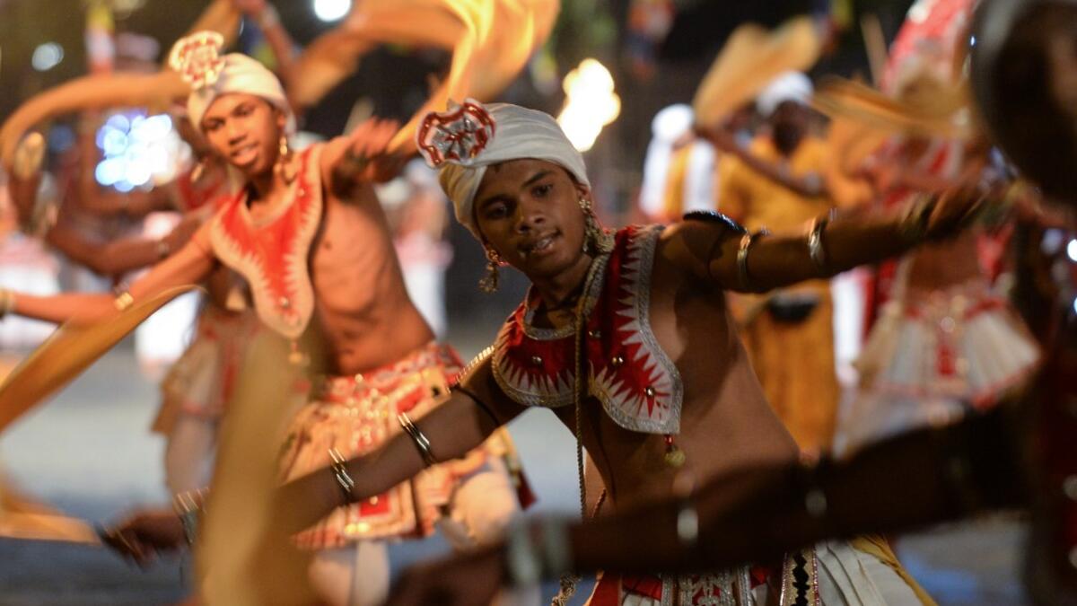 In this photograph taken on August 14, 2019 dancers perform during the "Esala Perahera" festival near the Buddhist temple of the Tooth in the ancient hill capital of Kandy, some 116 kilometres from Colombo. Lakruwan WANNIARACHCHI / AFP