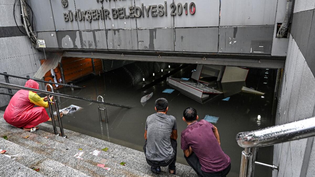 Shop owners look at their belongings in a flooded undergate shop center on August 17, 2019 in Eminonu district in Istanbul, after a heavy rainfall. Turkey's mega city Istanbul was lashed by a heavy rainstorm on August 17, killing a homeless man and leaving parts of the historic Grand Bazaar flooded.  Ozan KOSE / AFP