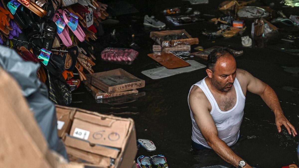A shop owner tries to save his belongings in a flooded undergate shop center on August 17, 2019 in Eminonu district in Istanbul, after a heavy rainfall. Ozan KOSE / AFP