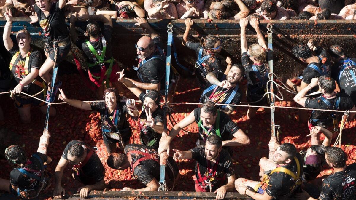 Revellers covered in tomato pulp take part in the annual "Tomatina" festival in the eastern town of Bunol, on August 28, 2019. JAIME REINA / AFP