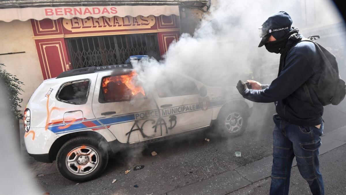 A protester dressed in black takes a picture of a burning French Municipal Police car on the sidelines of an anti-government demonstration called by the "Yellow Vests" (Gilets Jaunes) movement in Montpellier, southern France, on September 7, 2019. Pascal GUYOT / AFP