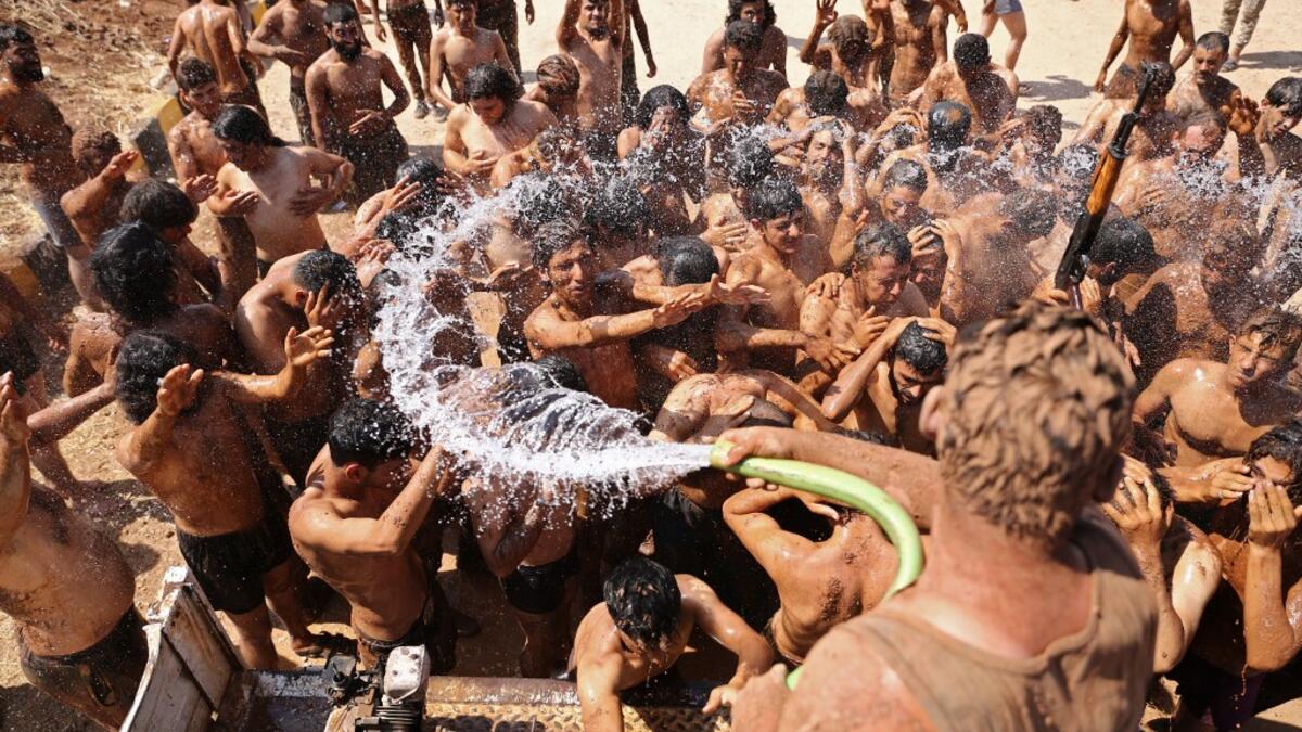 Syrian Turkish-backed fighters from al-Mutasim Brigade shower after finishing their training at a camp near the town of Marea in Syria's northern Aleppo district, on September 12, 2019. Nazeer Al-khatib / AFP