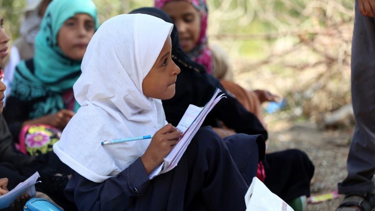 School children attend an open-air class under a tree near their unfinished school in the southwestern Yemeni village of al-Kashar in Taez governorate's Mashraa and Hadnan district at the start of the new academic year in the war-battered country.  Ahmad AL-BASHA / AFP