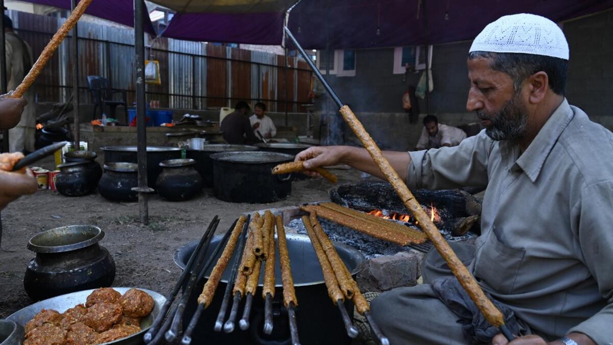 In this photo taken on September 15, 2019, chefs prepare long kebabs made from minced meat ahead of a traditional feast held for a marriage ceremony in Kashmir's Baramulla district, north of Srinagar. TAUSEEF MUSTAFA / AFP