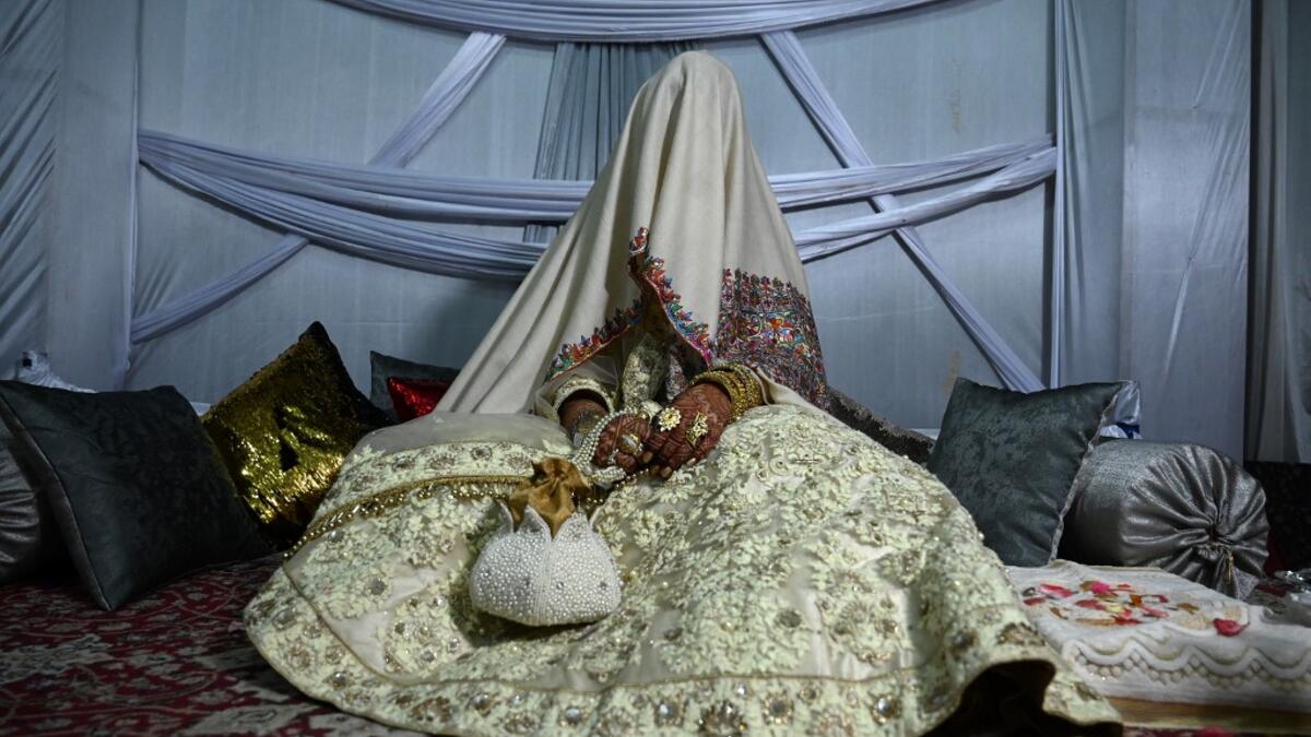 In this photo taken on September 15, 2019, a bride with her face and body covered with a shawl sits in her new husband's home following their marriage in Kashmir's Baramulla district, north of Srinagar. TAUSEEF MUSTAFA / AFP
