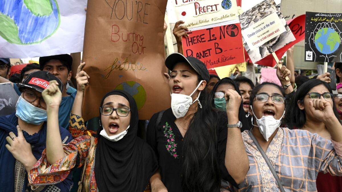 Youths hold placards as they march for a climate strike to protest against governmental inaction towards climate breakdown and environmental pollution, part of demonstrations being held worldwide in a movement dubbed "Fridays for Future", in Lahore on September 20, 2019. ARIF ALI / AFP