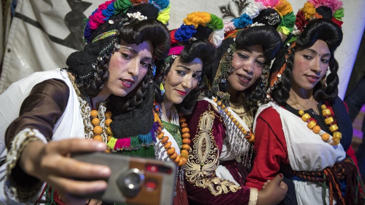 Young Amazigh (Berber) women pose for a selfie photograph during the annual "Engagement Moussem" festival near the village of Imilchil in central Morocco's high Atlas Mountains on September 21, 2019. Each year in the High Atlas Mountains hamlet of Ait Amer, tribes celebrate with dances and music, the collective wedding of young Amazigh couples during the traditional festival of "Engagement Moussem". FADEL SENNA / AFP
