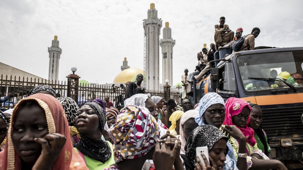 Worshippers are seen waiting outside the Great Mosque of the Mourides on September 27, 2019 in Dakar, ahead of its inauguration. Senegal's influential Mouride Brotherhood will inaugurate a 30,000-capacity mosque in the capital Dakar, said to be the largest in West Africa. JOHN WESSELS / AFP