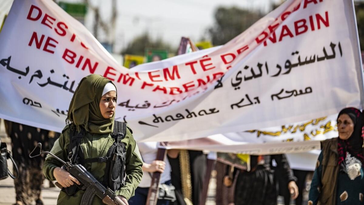 A member of the Kurdish Internal Security Police Force stands guard during a demonstration in front of the United Nations offices in the Kurdish-majority city of Qamishli in northeast Syria on October 2, 2019 over the Kurds exclusion from the UN-backed constitutional committee. Delil SOULEIMAN / AFP