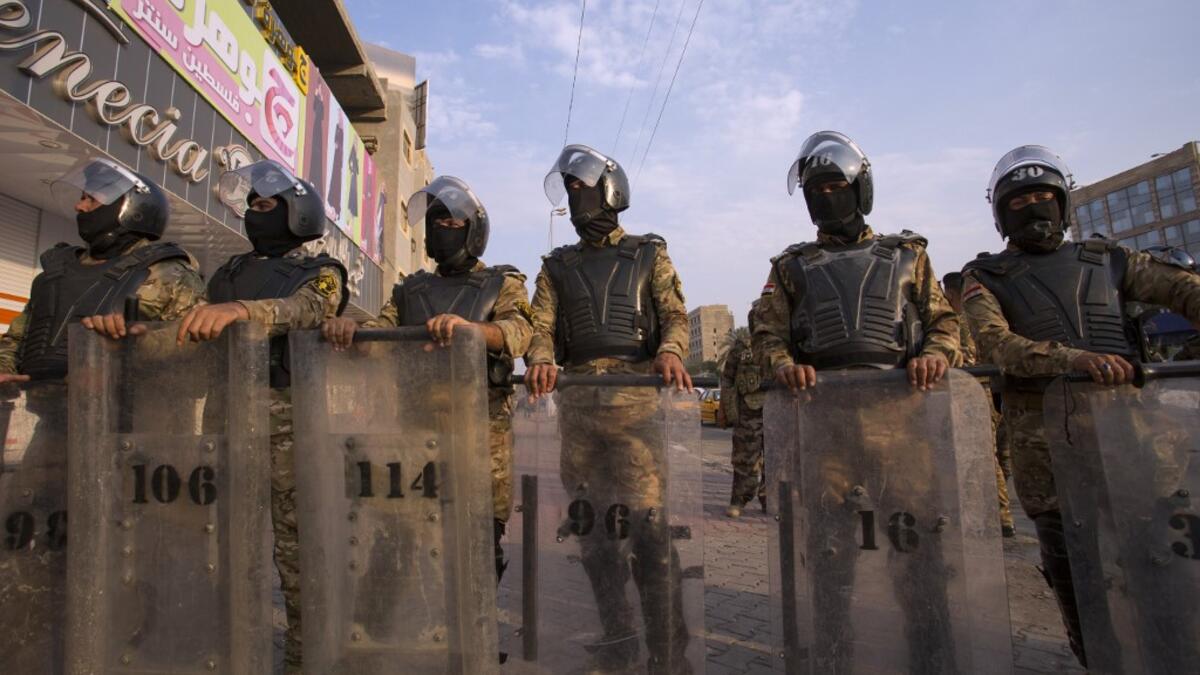 Iraqi riot police stand guard as protestors take part in a demonstration against state corruption, failing public services and unemployment, on October 2, 2019 in the southern city of Basra. Popular protests multiplied across Iraq today as thousands of demonstrators braved live fire and tear gas in rallies that have left seven dead in the past 24 hours. Hussein FALEH / AFP