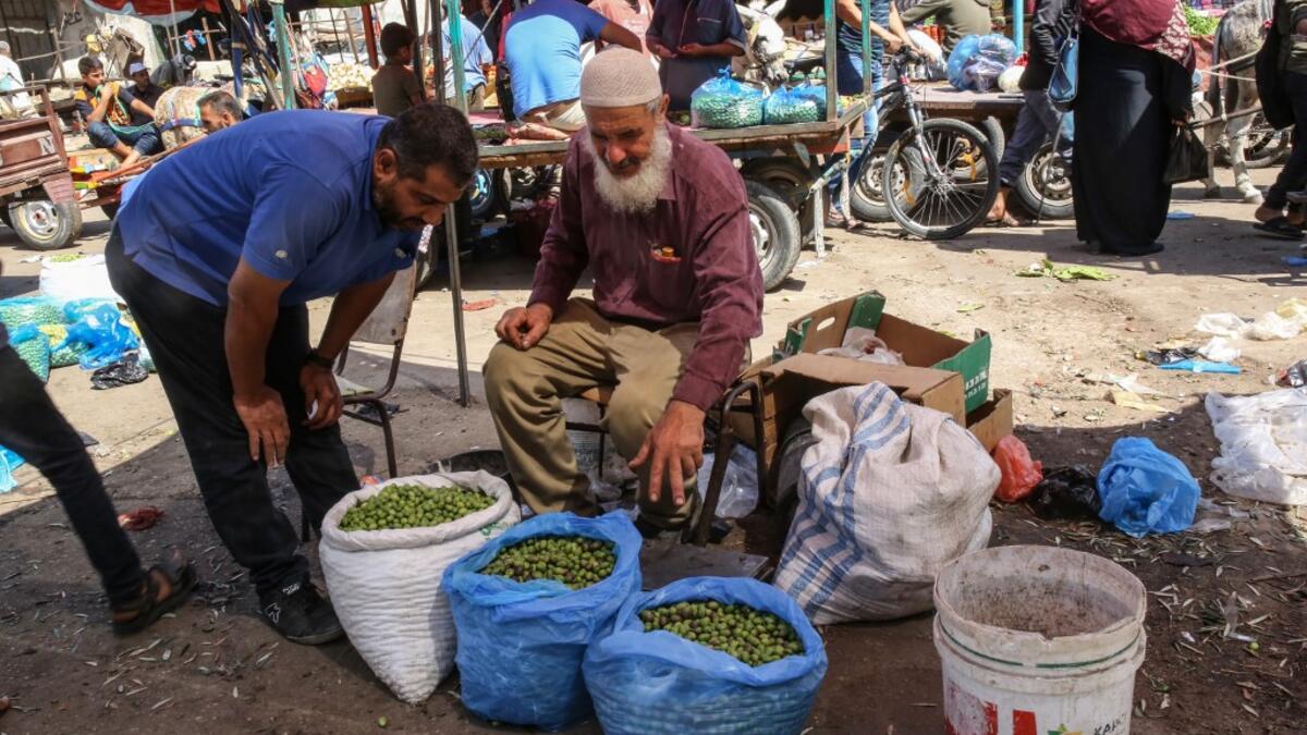 An elderly Palestinian man sell olives at a market during harvest season in Khan Yunis in the southern Gaza Strip on October 6, 2019. SAID KHATIB / AFP